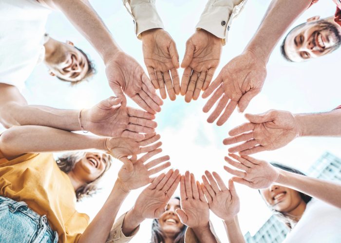 Group of young people stacking hands outdoors - Teamwork concept with guys and girls support each other - College students standing together outside