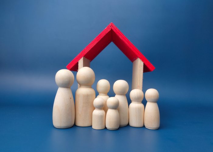 A family wooden doll with wooden house on a blue background.